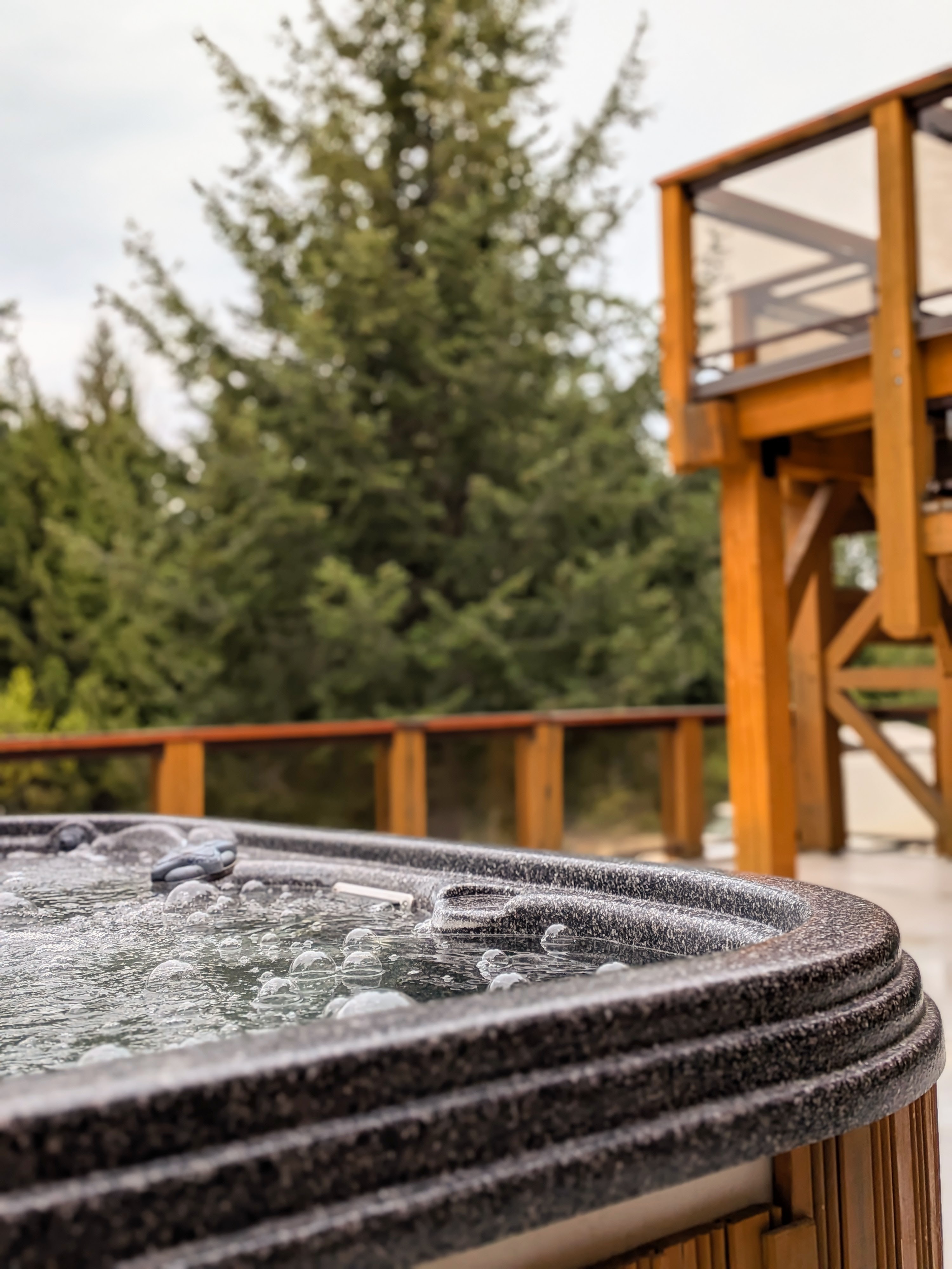 Private hot tub on the deck surrounded by trees