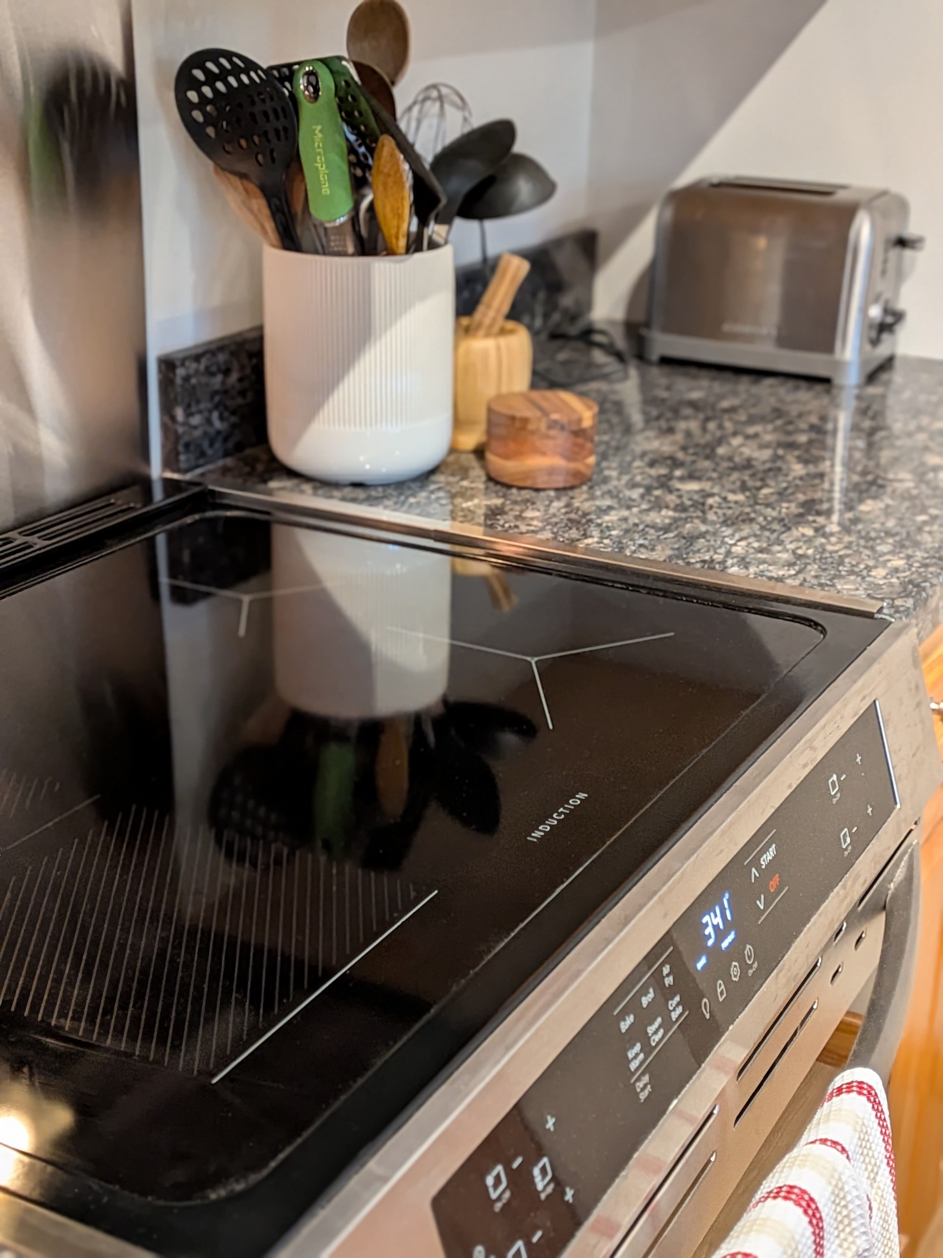 Kitchen with induction stove and stone backsplash